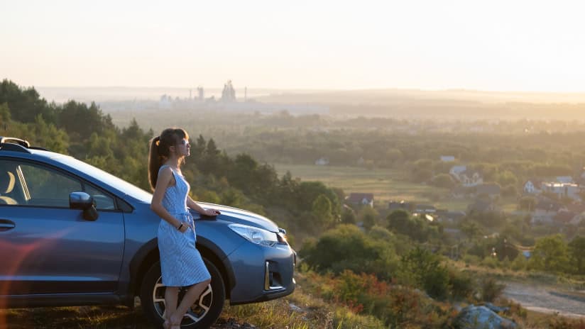 Girl standing by car