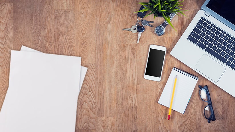 Desk with phone laptop documents wider