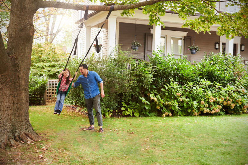 man pushing son on swing