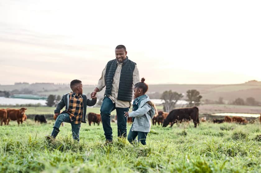 Father and kids walking through field