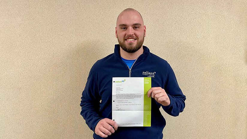 Mike Sweet holding Helping People Achieve More thank you letter