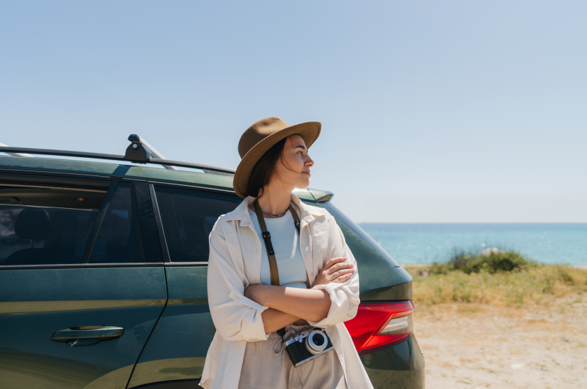 Woman at beach next to SUV