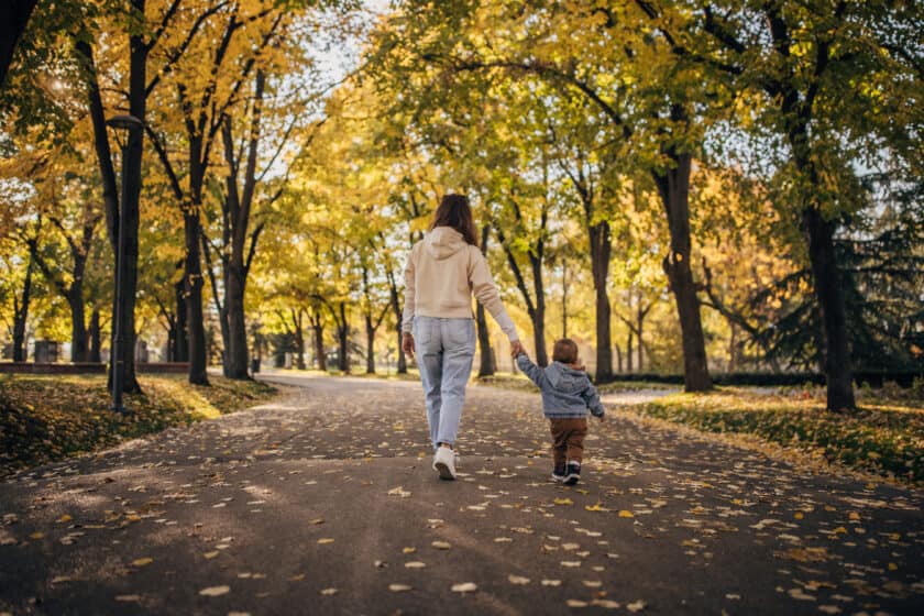 Mother and child walking through park